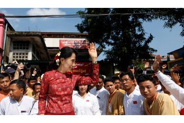 La leader de l’opposition pro-démocratique birmane, la prix Nobel de la Paix, Aung San Suu Kyi, salue ses partisans alors qu’elle quitte les locaux de sa formation politique, la Ligue nationale pour la démocratie où elle a assisté à une cérémonie marquant le 64e anniversaire de l’indépendance du pays.