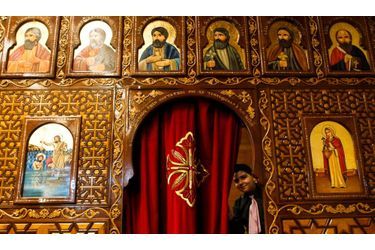 Un petit garçon ouvre un rideau de l’église copte de Francfort durant la messe de Noël. Les chrétiens coptes du monde entier sont en deuil après les attentats qui ont touché leur communauté en Egypte la semaine dernière.