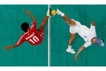 Le Sud-coréen Lee Jun-ho et le Birman Zaw Zaw Aung se livrent un duel en haute altitude lors de la finale de l&#039;épreuve du Sepak Takraw, un sport qui mélange football et volley-ball, lors des 16e Jeux asiatiques disputés à Guangzhou.
