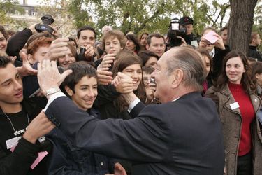 11 novembre 2005. Bain de foule pour Jacques Chirac souriant, serrant les mains de jeunes après les cérémonies du 87ème anniversaire de l'armistice de 1918 à l'Arc de Triomphe à Paris.