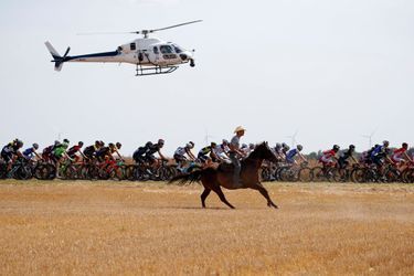 Un homme à cheval suit les coureurs lors de la sixième étape le 6 juillet.  