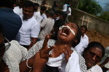 Une femme en larmes lors d'un enterrement collectif près de l'église Saint-Sébastien, à Negombo, au Sri Lanka mardi.