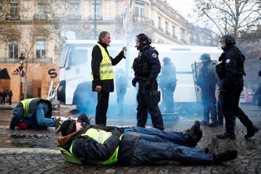 Un gilet jaune s&#039;explique avec un policier, samedi sur les Champs-Elysées.