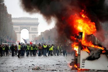 Une barricade de gilets jaunes en flammes, samedi sur les Champs-Elysées.