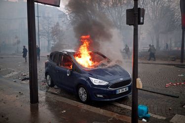 Une voiture en flammes sur les Champs-Elysées à Paris, samedi.