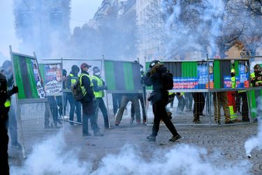 Face-à-face dans un brouillard de gaz lacrymogène sur les Champs-Elysées, samedi.
