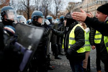 Des manifestants face aux policiers, samedi, sur les Champs-Elysées.
