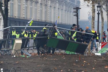 Des manifestants s'emparent du mobilier urbain sur les Champs-Elysées, samedi.