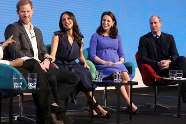 Deux couples, deux styles. Meghan, la main sur le bras d&#039;Harry, en compagnie de Kate et William, les mains croisées, lors du premier forum annuel de leur Royal Foundation, à Londres le mercredi 28 février 2018. 