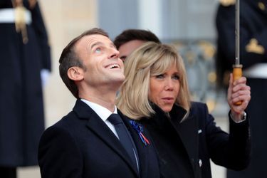 Emmanuel et Brigitte Macron sous les parapluies