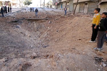 Des habitants d&#039;Alep autour d&#039;un cratère dans le quartier d&#039;al-Qaterji, le 23 novembre.