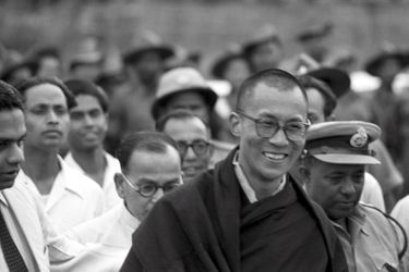 Traqué par les Chinois, le 14e DALAI-LAMA (23 ans) a fui le Tibet et trouvé refuge en Inde : 18 avril 1959 : son arrivée à la frontière de l&#039;Assam, après avoir traversé la région des territoires de la North East Frontier Agency (NEFA) qui sépare l&#039;Inde du Tibet et de la Chine. Avant de rejoindre la ville de Tezpur où lui et ses partisans sont attendus par la presse internationale, le Dalai-Lama fait quelques pas pour saluer le comité d&#039;accueil venu l&#039;attendre à la frontière.