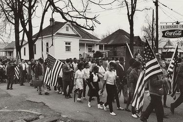 Par AFP. "Le travail n'est pas terminé": Barack Obama célèbre samedi à Selma (Alabama) la marche pour les droits civiques qui a marqué un tournant dans l'histoire des Etats-Unis en garantissant le droit de vote aux Afro-Américains des Etats du Sud.Le premier président noir de l'histoire des Etats-Unis doit s'exprimer devant le pont Edmund Pettus sur lequel, le 7 mars 1965, plusieurs centaines de manifestants pacifiques furent violemment repoussés par la police dans un assaut qui traumatisa l'Amérique et aboutit, quelques mois plus tard, au Voting Rights Act.Barack Obama avait trois ans au moment des faits. Il a appris cette histoire par sa mère, quand il avait "six, sept, huit ans". "Elle me donnait des tas de livres pour enfants sur la lutte pour les droits civiques. Elle mettait des chansons de Mahalia Jackson (qui fut une proche de Martin Luther King, NDLR)", a-t-il raconté à la veille de cette célébration.Le discours présidentiel intervient trois jours après la publication d'un rapport accablant du ministère de la Justice pointant les comportements discriminatoires de la police de Ferguson (Missouri), théâtre de violentes émeutes après la mort en août dernier d'un jeune Noir abattu par un policier blanc.Selma, ville de 20.000 habitants (dont 80% de Noirs), se prépare depuis plusieurs jours à ce week-end de commémoration auquel l'ancien président George W. Bush et plus d'une centaine d'élus du Congrès doivent participer.Le 15e amendement de la Constitution américaine, adopté en 1870, interdit de refuser le droit de vote à tout citoyen "sur la base de sa race ou de sa couleur". Dans plusieurs Etats du Sud, il a longtemps été bafoué."Au rythme actuel, il faudra 103 ans pour que les 15.000 Noirs du comté de Dallas puissent s"inscrire sur les listes électorales", lançait Martin Luther King en janvier 1965 à Selma.Si la loi signée le 6 août 1965 par le président Lyndon Johnson a marqué une rupture, nombre d'activistes considèrent que ce chapitre n'est pas clos.