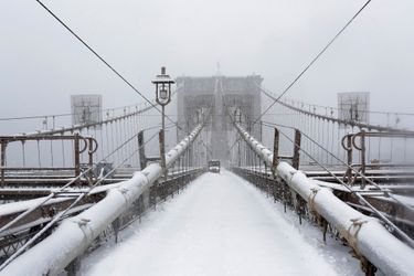 A worker clears snow on the Brooklyn bridge in New York