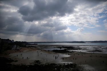  A general view of people who dot the beach as they dig for shellfish during a record low tide in Saint Malo,