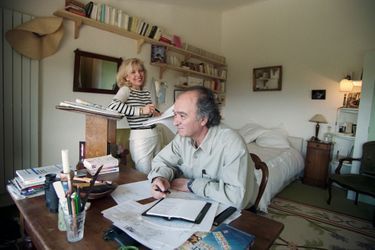 Georges WOLINSKI dans sa chambre, installé à son bureau. Son épouse Maryse se tient auprès de lui