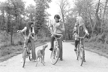 En région parisienne, portraits en extérieur de l&#039;animateur de télévision Michel Drucker, en compagnie de son épouse la comédienne Dany Saval et de sa fille Stéphanie, faisant du vélo dans une allée boisée, accompagnés de leurs chiennes lévrier.