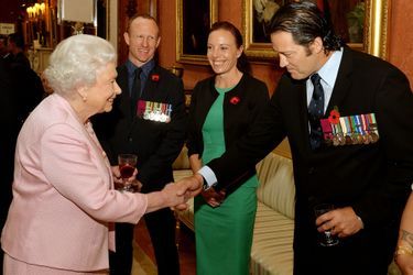 La reine d’Angleterre Elizabeth II reçoit avec le prince Philip des héros détenteurs de la Victoria Cross et de la George Cross au palais de Bu...