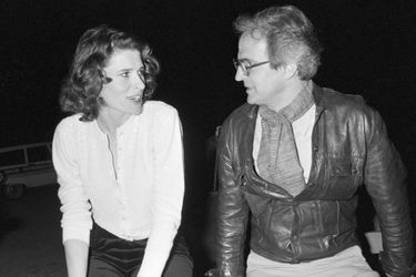 France, Grenoble, 8 mai 1981, pendant le tournage du film "La femme d'à côté", lors d'une soirée de repos, le réalisateur François TRUFFAUT est assis sur une barrière de bois près de l'actrice Fanny ARDANT, à l'époque sa compagne. Ils se regardent. Derrière eux, des voitures garées.