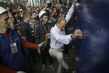 Vladimir Poutine escalade un mur au bord du lac Seliger, en août 2011