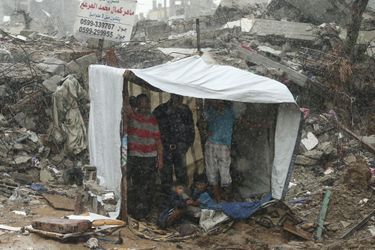 Des Palestiniens s&#039;abritent sous un drap dans les ruines de leur maison, à Gaza