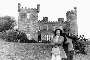 Attitude souriante de Charlotte RAMPLING appuyée contre Philippe NOIRET fumant un cigare devant le château de MALBURY où se tourne leur film "Un taxi mauve" d'Yves BOISSET.
