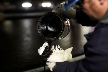Un ouvrier teste un échantillon de pétrole après la première étape de filtrage