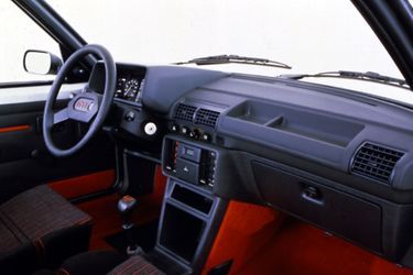 A l&#039;intérieur de la 205 GTI, des touches de rouge signalent la vocation sportive de la voiture. 