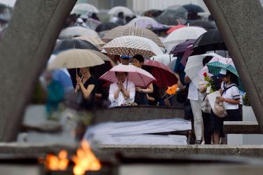 Des gens priant devant le Memorial de la paix