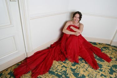 L'actrice belge est en robe de soirée rouge Elie Saab, assise par terre dans une chambre de l'hôtel Carlton, lors du Festival de Cannes 2006.