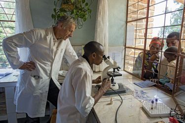 Au microscope le Dr Léonard examine un échantillon sanguin, à la recherche du parasite de la malaria.
