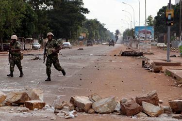 Des soldats de la Misca déblayent des barricades érigées par les manifestants sur l'un des axes principaux du centre ville de Bangui.