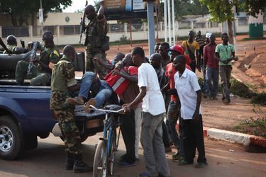 Proches de la place des Nations Unies, des gendarmes centrafricains récupèrent un homme blessé par balle lors des échauffourées entre les soldats de la Misca et la population qui réclame leur départ.