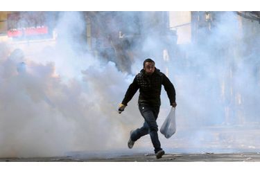 Un manifestant fuit les gaz lacrymogènes, lors d'affrontements avec les forces de sécurité, au Caire, en Egypte. Le manifestants demandent toujours la tenue prochaine d'une élection présidentielle et un transfert rapide du pouvoir à des autorités civiles.