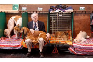 Un homme est assis avec son chien, au dernier jour de la compétition au Crufts, la plus grande exposition canine du monde qui se déroule chaque année à Birmingham.