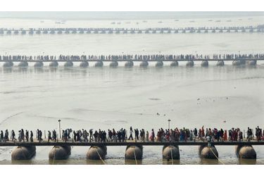 Des fidèles se pressent sur les pontons enjambant le Sangam, la confluence entre le Gange, la Yamuna et la Sarasvati. Pendant le mois de Magh, les hindous viennent prendre un bain dans ces eaux sacrées.
