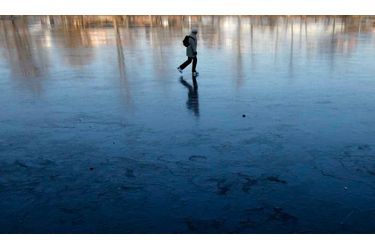Une femme fait du patin à glace sur un étang gelé de Prague.