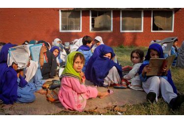 Des petites filles assistent à une leçon en dehors de leur salle de classe, endommagées par les bombardements de dimanche dernier, attribués à des activistes présumés, dans le district de Swabi, au Pakistan.