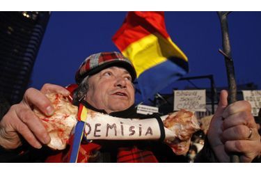 Un protestataire tient un os sur lequel on peut lire le mot «démission» lors d’une manifestation à Bucarest. Les opposants au gouvernement Roumain demandent la démission du Premier ministre Emil Boc.