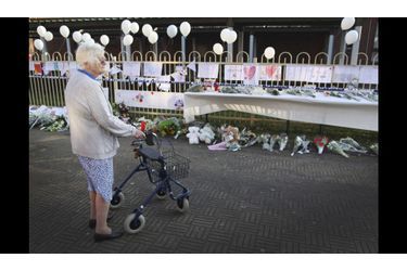 Une retraitée regarde les fleurs déposées en face de l’école ‘T Stekske, à Lommel, où étaient scolarisés 15 des 22 enfants belges décédés dans l’accident de car en Suisse. Vingt-quatre autres passagers sont toujours à l&#039;hôpital, dont trois enfants dans un état grave.
