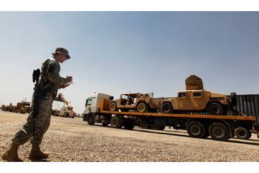 Un soldat vérifie le nombre de véhicules transportés par un camion sur la base de Balad, à 80 km au nord de Bagdad, en août 2010. Le mouvement de retrait a en effet commencé depuis plus d&#039;un an.