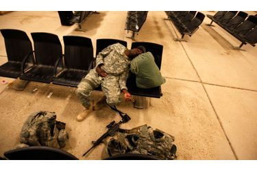 Un soldat de l&#039;U.S. Air Force, épuisé, dort dans un hall de la base aérienne de Al-Asad en entendant son vol.