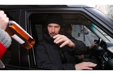 L&#039;acteur canadien Keanu Reeves reçoit une bouteille de vin alors qu&#039;il quitte son appartement de Budapest.