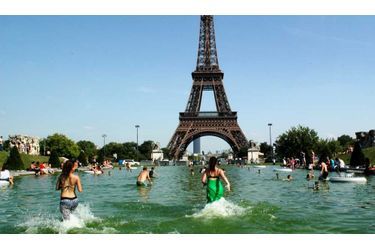 Les Parisiens se baignent dans les lacs ornementaux qui entourent la tour Eiffel, alors que le thermomètre affiche plus de 30 degrés dans la capitale depuis hier.