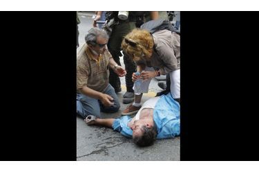 <br />
Les paramédics s’affairent autour d’une victime. Les affrontements auraient fait une douzaine de blessés, d’après les autorités grecques. 