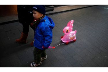  Un petit garçon marche dans les rues de Shanghai, trainant un jouet en forme de lapin. Le nouvel an chinois commence aujourd’hui, début de l’année du lapin.