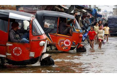 <br />
Des conducteurs de Bajaj, véhicules à deux roues, attendant des clients dans les rues inondées de Muara Baru, au nord de Jakarta.<br />
  