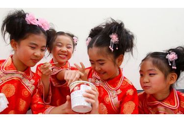 Des petites filles partagent un pot de glace avant de se représenter à l&#039;occasion du 75ème anniversaire du Dalaï Lama, hier à Taïpei. 