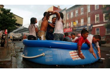 Des enfants se rafraichissent dans une piscine gonflable posée dans l’une des rues du quartier de Brooklyn à New York afin de lutter contre une vague de chaleur qui s’est installée dans la ville.