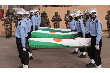 Les corps des gendarmes tués dans l'opération échouée de libération des deux jeunes Français samedi à Niamey, sont recouverts du drapeau national, lors d'une cérémonie leur rendant hommage, dans la capitale nigérienne, en présence d'Alain Juppé. 